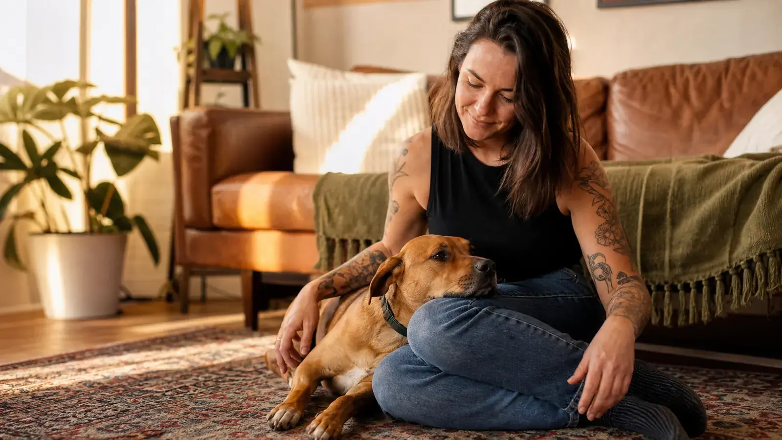 Owner and dog sitting on a living room floor together after a successful dental chew session